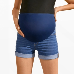 Detail of high-waisted elastic maternity belly band on blue denim shorts with folded hems
