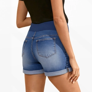Detail view of denim maternity shorts featuring a high elastic belly support band and rolled hems