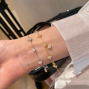 French style gold and silver clover bracelets with sparkling cubic zirconia on female wrist