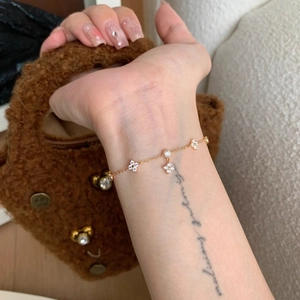 French style gold bracelet with sparkling zircon clover charms and delicate tassel chain