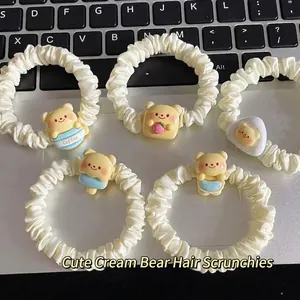 Lot de cinq chouchous ours crème avec figurines en résine posés sur un clavier