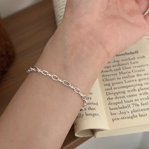 Close-up of minimalist S925 sterling silver geometric link bracelet on model wrist
