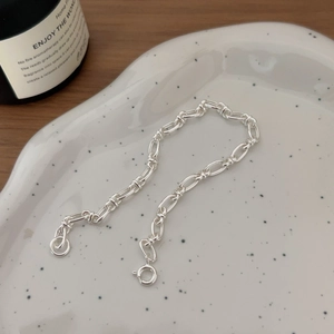 Minimalist S925 sterling silver geometric chain bracelet on white ceramic plate