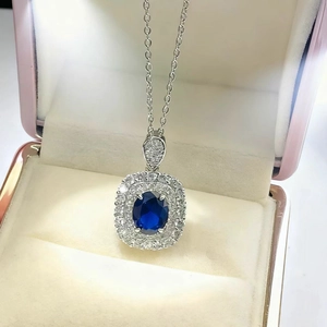 Detailed view of luxury royal blue oval sapphire pendant necklace with diamond halo