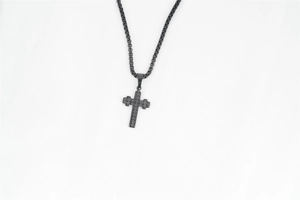 Détail du pendentif croix en acier noir avec texture étoilée et chaîne vénitienne