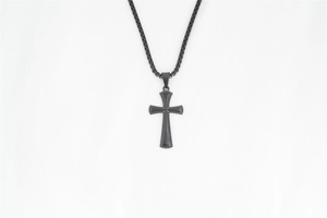 Détail du collier croix noir mat avec bordure pointillée et chaîne à mailles carrées