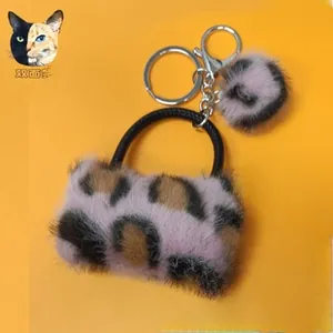 Detailed close-up of a pink leopard print plush handbag keychain with silver metal ring