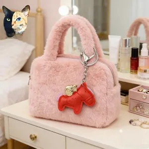 Detailed texture of pink plush handbag with a red leather horse charm on a white table
