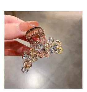 Detailed close-up of champagne crystal hair claw clip with faceted sparkling stones