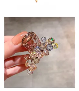 Close-up of small hair claw clip with colorful crystals and champagne glass beads