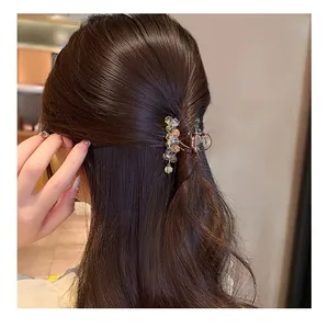 Detailed close-up of crystal beaded hair claw clip with champagne beads and dangling tassels