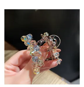 Detailed macro of crystal hair claw clip with iridescent beads and metallic spring