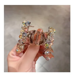 Close-up of crystal claw hair clip with iridescent beads and gold metal spring mechanism