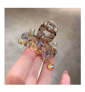 Detailed view of brown claw clip with colorful crystals and hanging jewel pendant