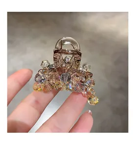 Detailed close-up of macaron crystal hair claw with iridescent AB coating beads
