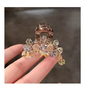 Macro view of crystal hair claw clip with champagne and purple beads on metal base
