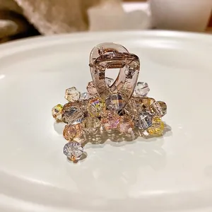 Luxurious crystal hair claw clip with colorful macaron beads on a round white tray
