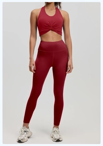 Detailed close-up of dark red halter yoga bra with twist front and high-waist leggings