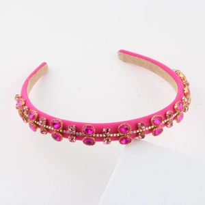 Detailed close-up of rose pink satin headband with hand-set pink rhinestones on white stand