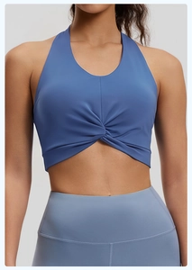 Detail of dark blue halter sports bra featuring a twist front design and breathable fabric