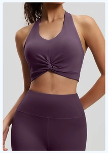 Detail of dark purple sports bra with chest twist design and high waist leggings