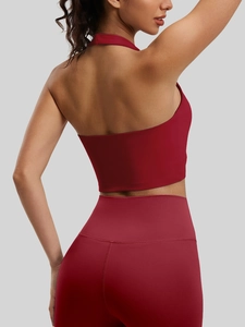 Burgundy backless halter sports bra and high waist leggings set shown from a side view