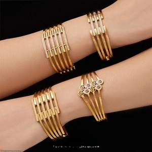 Detailed view of four 18K gold plated hollow bangles with striped and geometric patterns