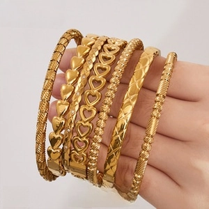 Detail view of 18k gold plated bangle set with heart and twisted rope patterns