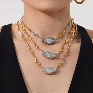 Detailed view of triple-layered wavy chain necklace with pearls and crystal pendants