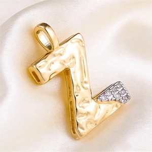 Hammered gold letter Z pendant with micro-set zircon stones on silk background