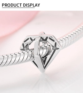 Macro shot of S925 silver hollow diamond-shaped charm on a sleek snake bone bracelet