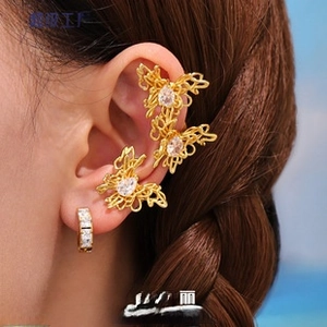 Detailed view of butterfly-shaped gold ear cuff and stud set with clear zircon stones