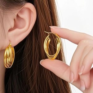 Close-up of golden multi-layer intertwined titanium hoop earrings for a stylish look