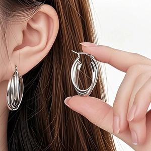 Detailed view of silver titanium steel earrings with triple interlinked hoop design