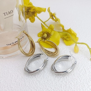 Detailed view of triple-hoop interlinked earrings in gold and silver finishes