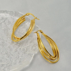 Close-up of golden multi-layered oval hoop earrings with interlocking polished bands