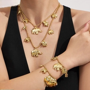 Detail view of double-layer gold beaded necklace and bracelet with elephant pendants