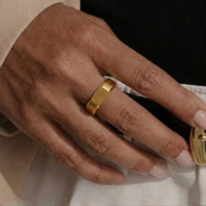 Macro view of a gold geometric rectangular ring with a brushed metallic texture finish