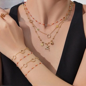 Close-up of layered U-shaped horseshoe pendant necklace with beads and floral details