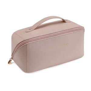 Macro shot of pink leather makeup bag with gold hardware and top handle detail