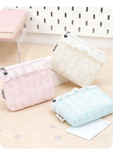 Three daisy print cosmetic bags in pink, beige, and blue with heart zipper and lace detail