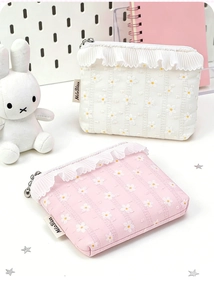 Close-up of floral embroidery on portable pouches with elegant lace trim and zippers