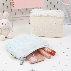 Floral embroidered makeup bags in blue and beige with heart zipper and ruffle edge