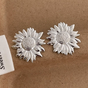 Macro shot of 18K gold plated sunflower studs showing intricate petal texture