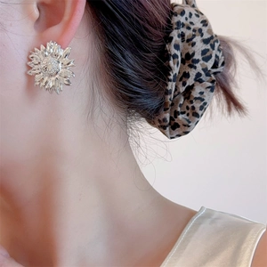 French vintage sunflower stud earrings in polished silver finish on model ear