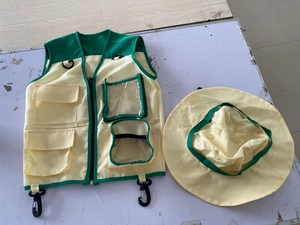 Flat lay of a multi-pocket kids adventure vest and wide-brim hat in beige and green