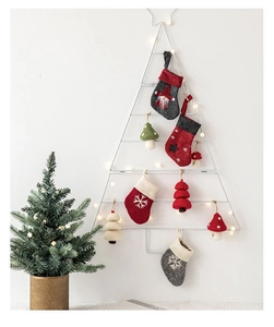 Close-up of felt Christmas ornaments including stockings and trees on white metal frame