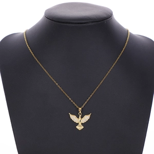 Detailed close-up of golden peace dove necklace with pavé stones on a black neck bust