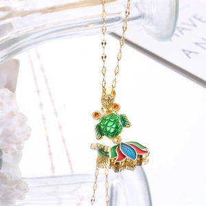 Detailed close-up of a goldfish pendant necklace with green enamel and gold finish