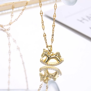 Macro view of gold rocking horse pendant with clear cubic zirconia pavé on a flat link chain